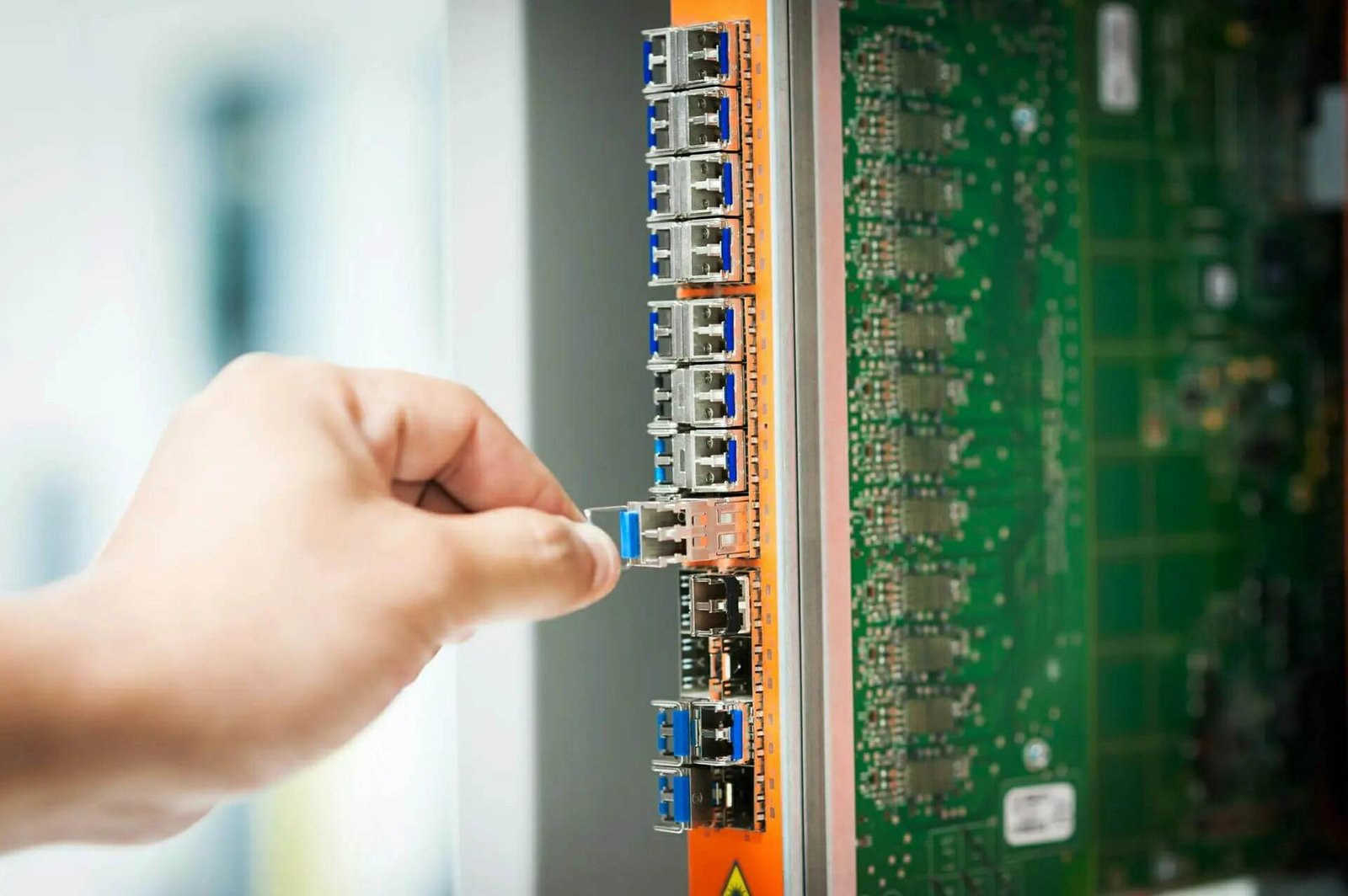 Technician connecting a cable to network equipment for an FTTX deployment